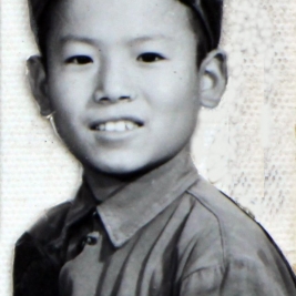 四年级时的照片。这张照片的服装充分反映了那个时代的特点:绿军衣、绿军帽,胸前佩戴毛主席像章,左臂带菱形红小兵臂章